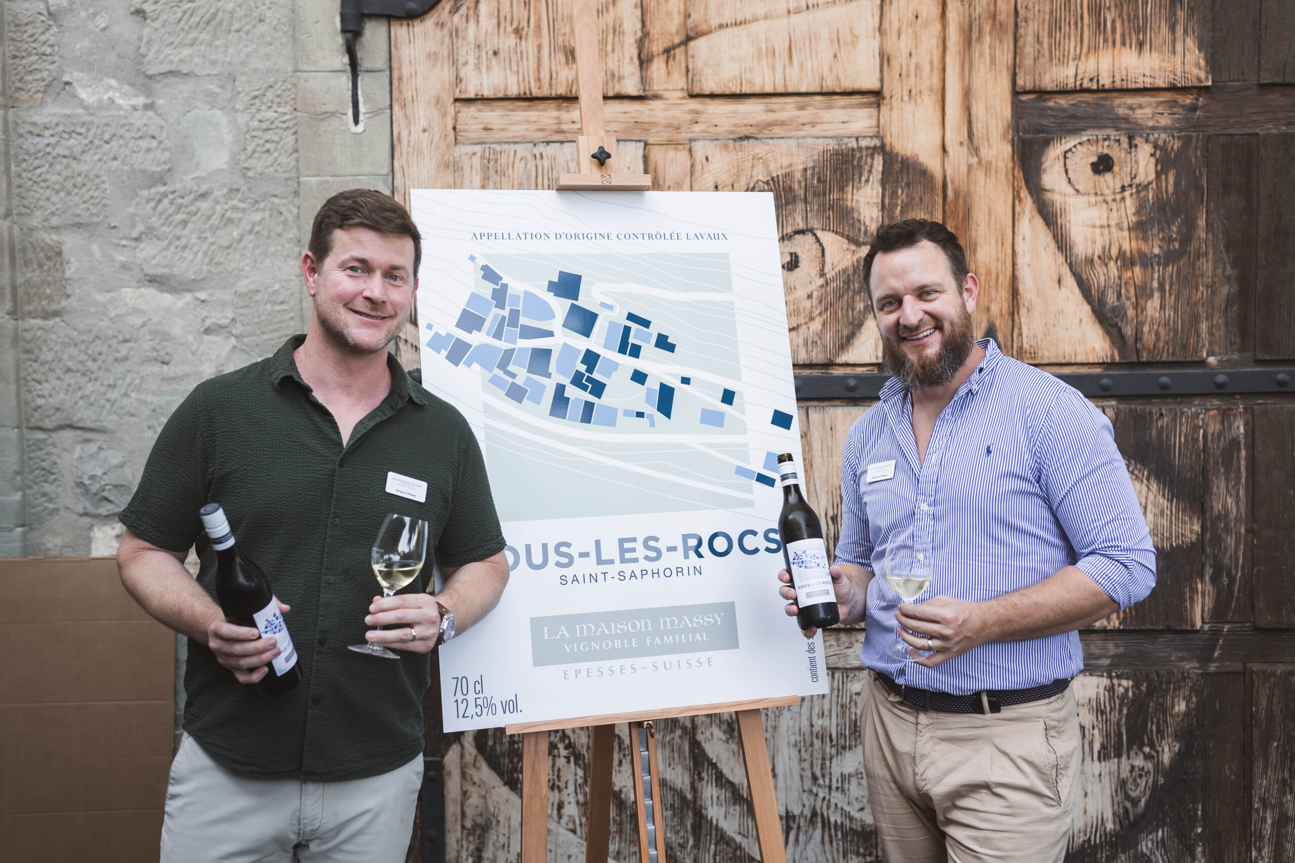 Deux hommes posant devant une pancarte de vin Sous-les-Rocs