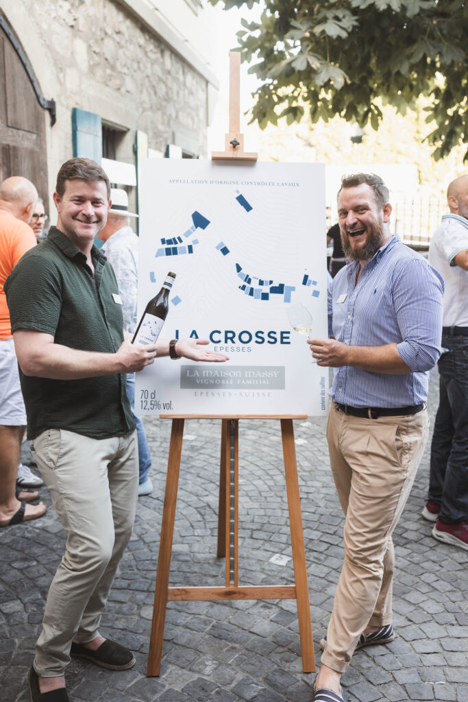 Deux hommes posant devant une pancarte de vin La Crosse