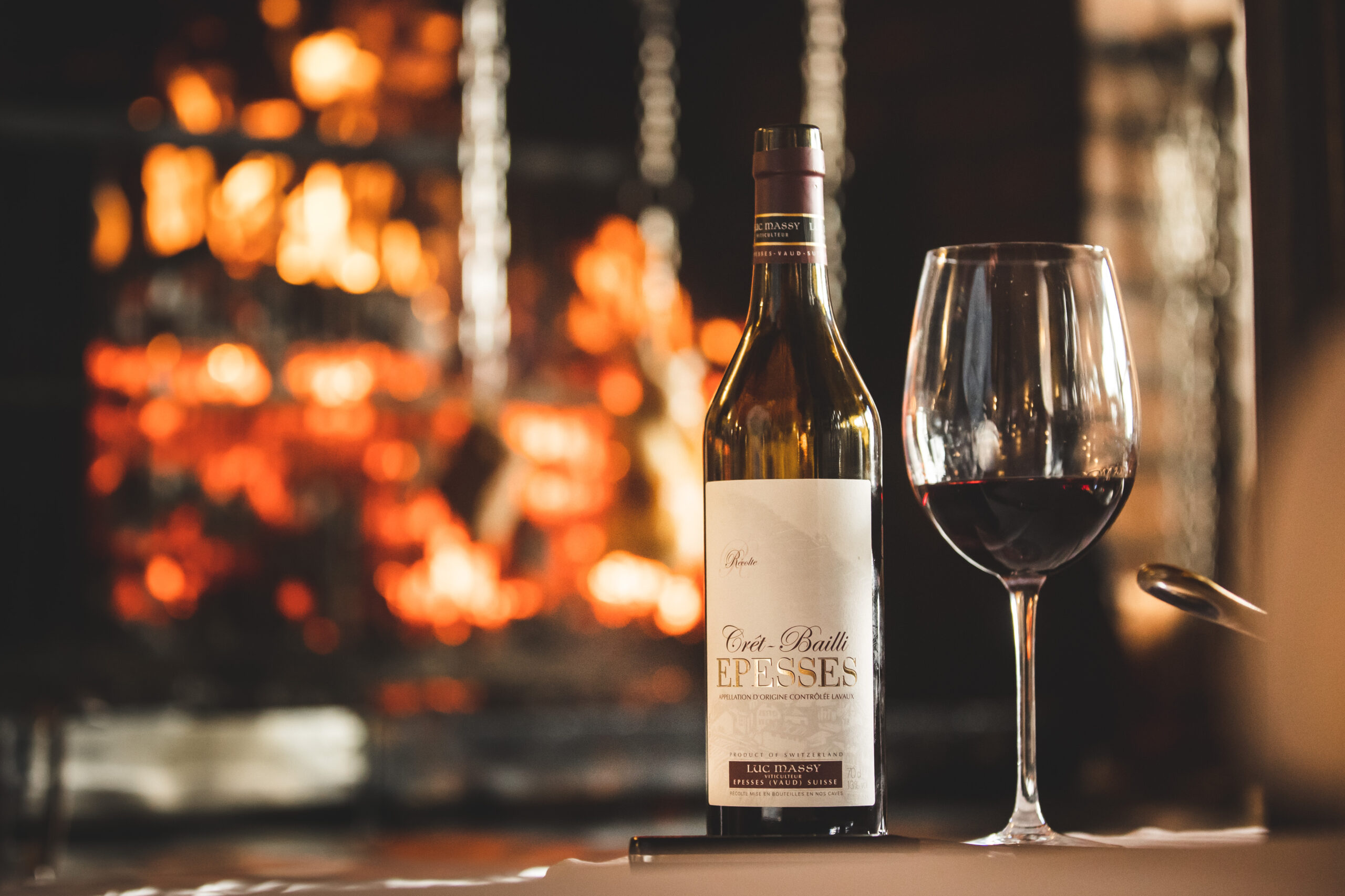 Une bouteille et un verre de vin rouge posés sur une table